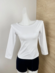 Close-up of the fine knit texture and neckline of the white slim fit boat neck top