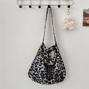 Detail of grey leopard print canvas tote bag hanging on a minimalist white wall rack