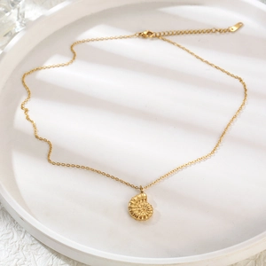 Detail of 18K gold-plated titanium steel conch pendant with adjustable chain on white tray