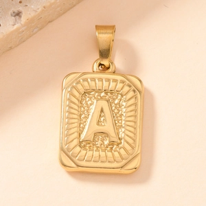 Macro shot of gold square pendant featuring an embossed letter A with radiant border