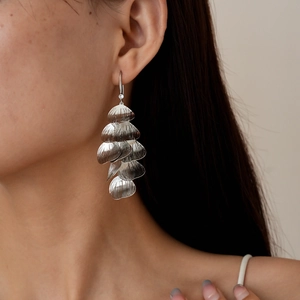 Detailed close-up of tiered silver leaf tassels earrings with subtle crystal accent