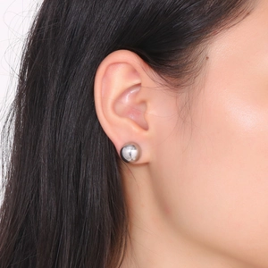 Detailed view of a silver hollow semi-circle earring worn on ear with metallic shine