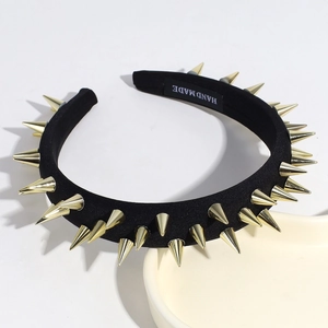 Detail of black fabric headband with gold metal spikes and white HAND MADE label