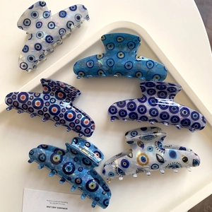Set aus sechs blauen Evil Eye Haarklammern in verschiedenen Mustern auf weißem Tablett