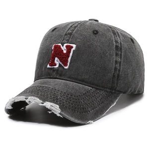 Vintage dark gray baseball cap with red N patch and distressed brim in 45-degree view