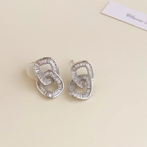 Detail of 18K silver studs with interlocking rings and rectangular zircon inlay