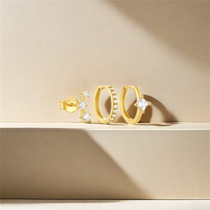 Detailed macro view of three gold S925 sterling silver earrings set with clear zircon stones