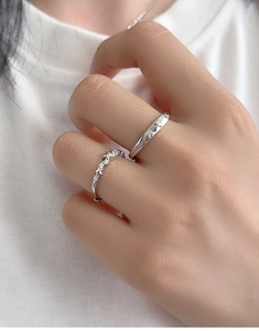 Close-up of S925 sterling silver couple rings with minimalist star pattern and fine crystals