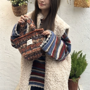 Detail of multi-color knit plush tote bag featuring a textured finish and brand label