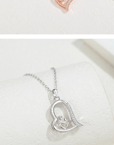 Macro shot of S925 silver heart necklace with mother and child silhouette and zircons