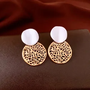 Orecchini tondi in oro 18k con dettaglio in resina bianca e design traforato chic