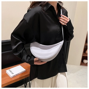 Close-up of lightweight nylon half-moon crossbody bag on black satin shirt