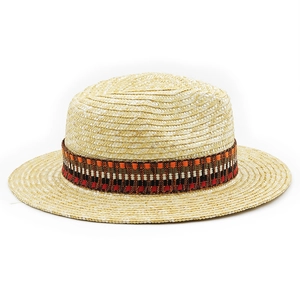 Detail of beige straw boater hat with a colorful ethnic woven band and texture