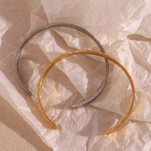 Top view of gold and silver open bangles with unique hammered texture on crumpled paper