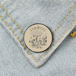 Cartoon frog and mushroom enamel brooch with moon phases on denim background