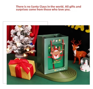 Close-up of green reindeer gift bag with gold box and festive Christmas decorations