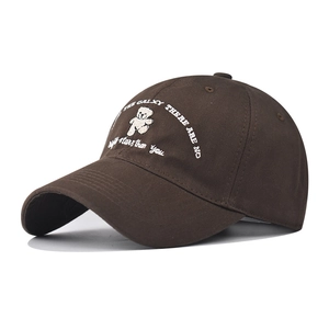 Detail of embroidered teddy bear and galaxy lettering on a dark brown cotton baseball cap