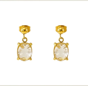 Détail de boucles d'oreilles dorées avec zircons ovales et sertissage à quatre griffes
