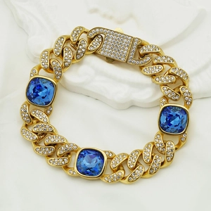 Détail macro du bracelet gourmette doré avec pierres bleues et cristaux de pavé