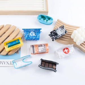 Variety of acetate hair claws featuring creative patterns like earth and medical cross symbols