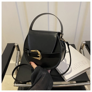 Detailansicht der schwarzen Satteltasche aus Leder mit goldener Schnalle auf Stuhl