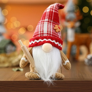 Christmas gnome decoration with red checkered hat and wooden rolling pin on table