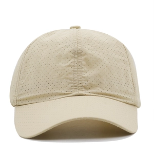Detailed macro view of beige quick-dry baseball cap featuring breathable eyelet mesh fabric