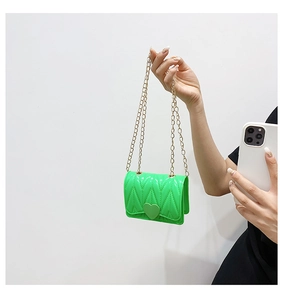 Detail of neon green silicone mini bag with gold chain strap and heart-shaped buckle