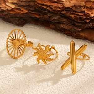 Detailed view of three gold-plated adjustable rings with bohemian sun and heart patterns