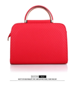Rear view of a red leather handbag featuring V-shaped texture and a gold metal handle