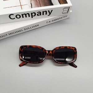 Flat lay of vintage leopard print sunglasses on books with a stylish fashion aesthetic