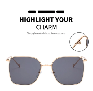 Detail of square gold metal sunglasses featuring deep gray lenses and adjustable nose pads
