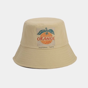 Détail de l'imprimé orange et du texte pastoral sur le bob en coton de couleur beige