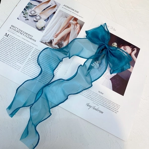 Macro detail of dark cyan organza ribbon with soft wavy edges on stylish background