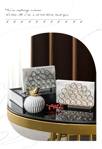 Detail view of crystal beaded napkin holders in gold and silver finish on a black tray