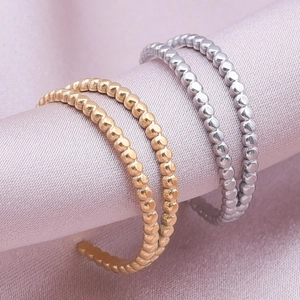 Polished gold and silver stainless steel beaded open rings on elegant pink silk