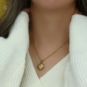 Detailed view of women's gold-tone rhombus pendant necklace featuring a square zircon stone