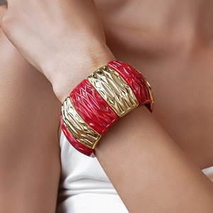 Close-up of wide stretch bracelet featuring red marble resin and gold textured metal