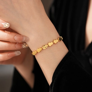 Macro shot of gold-tone gourd bracelet links showing polished and matte textures on wrist