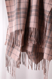 Close-up of pink and grey plaid scarf fabric texture with long fringe tassels