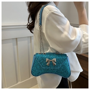 Blue sequin evening bag with metal chain and bow decoration shown worn on the shoulder