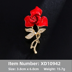 Detail of red rose brooch with golden leaves and sparkling white rhinestones