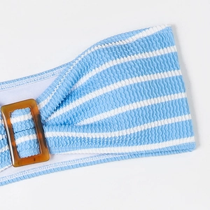 Detail of blue striped smocked bikini fabric with a decorative amber tortoise buckle