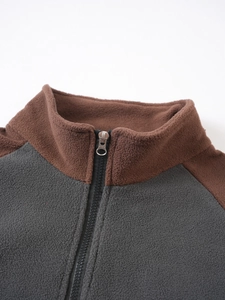 Close-up of tactical fleece jacket featuring stand collar and contrast zipper details