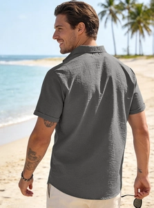 Outdoor back view of a men's dark grey linen shirt showing fabric texture and beach vibes