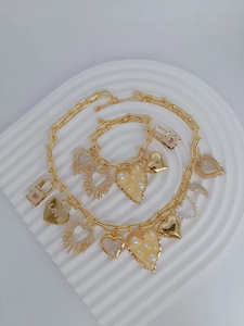 Nahaufnahme von goldenem Herzanhänger-Halsketten- und Armbandset mit Perlen und Kristallen