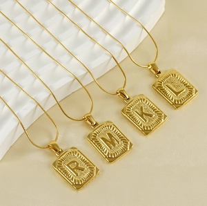 Détail de pendentifs carrés en acier plaqué or 18K avec les lettres R, M, K et L