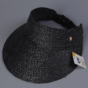 Detail of black woven raffia texture and UV care tag on a sun visor straw hat