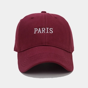 Close-up of white PARIS embroidery on a burgundy cotton twill baseball cap with brim stitching