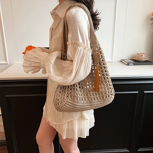 Khaki woven straw tote bag with tassel charm and hollow knit pattern for women